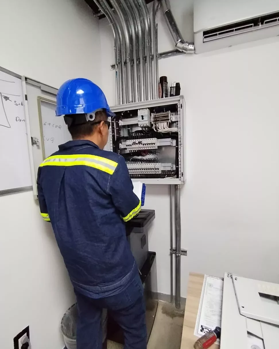 Técnico revisando un tablero de control eléctrico en una instalación residencial